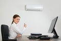 Businesswoman Using Air Conditioner In Office Royalty Free Stock Photo