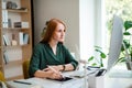 Young businesswoman sitting at the desk indoors in office, using computer. Royalty Free Stock Photo