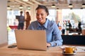 Young Businesswoman Sitting At Desk Working On Laptop In Modern Open Plan Office Royalty Free Stock Photo