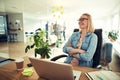 Young businesswoman sitting at her office desk laughing Royalty Free Stock Photo