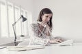 Young businesswoman sitting at her office desk making a telephone call using white phone Royalty Free Stock Photo