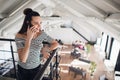 Young businesswoman is standing in cafe and talking on cell phone. Girl is waiting for friends, colleagues in restaurant Royalty Free Stock Photo