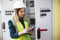 Young businesswoman standing in front of the control panel in the control room Royalty Free Stock Photo