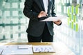 Young businesswoman standing holding a business graph to analyze the data in detail in the office