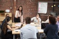 Young Businesswoman Standing And Leading Office Meeting Around Table Royalty Free Stock Photo