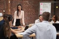 Young Businesswoman Standing And Leading Office Meeting Around Table Royalty Free Stock Photo