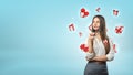 A young businesswoman stands thinking while small white and red gift boxes fly around her head.