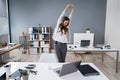 Businesswoman Stretching At Desk Royalty Free Stock Photo