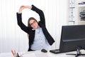 Businesswoman Stretching At Desk