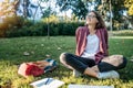 Young businesswoman student working on her notebook in park. Freelancer female sitting on grassy lawn using laptop computer with Royalty Free Stock Photo