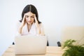 Young businesswoman suffering from headache in front of laptop at office Royalty Free Stock Photo