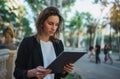 Young businesswoman with tablet walking in barcelona city park. Young business woman using modern laptop outdoors Royalty Free Stock Photo