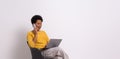 Young businesswoman talking over smart phone and using laptop on chair against white background Royalty Free Stock Photo