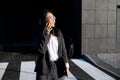 Young businesswoman talking on the phone and holding a laptop in her hands Royalty Free Stock Photo