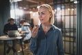 Young businesswoman talking on speakerphone in an office