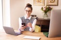 Young businesswoman text messaging while sitting at desk and working from home Royalty Free Stock Photo