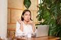 Young businesswoman thinking, frowning as sitting puzzled and complicated, using laptop in cafe Royalty Free Stock Photo
