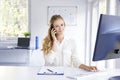 Young businesswoman using cell phone in the office Royalty Free Stock Photo