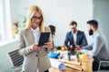 Young businesswoman using digital tablet while colleague in background Royalty Free Stock Photo