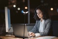 Young businesswoman using a laptop in her office at night Royalty Free Stock Photo