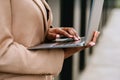 Young businesswoman using laptop while standing over building outdoors Royalty Free Stock Photo