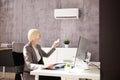 Young Businesswoman Using Air Conditioner Royalty Free Stock Photo