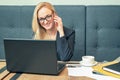 Young businesswoman wearing glasses is ringing on the phone with a client at the office.