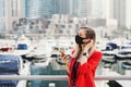 Young businesswoman wearing protective face mask standing at city business center and calling via smartphone Royalty Free Stock Photo