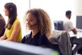 Young Businesswoman Wearing Telephone Headset Talking To Caller In Customer Services Department Royalty Free Stock Photo