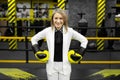 Young businesswoman in a white suit and boxing gloves in a boxing ring.