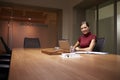 Young businesswoman working late in office smiles to camera