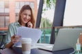 Young businesswoman working with papers and talking on mobile phone, reading financial documents while sitting at cafe Royalty Free Stock Photo