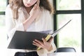 Young businesswoman at workplace and reading paper in office.businesswoman use internet smartphone at her workplace office Royalty Free Stock Photo