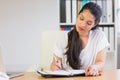 Young businesswoman writing in diary