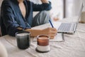 Young businesswoman writing notes while working. Concept of home office, remote work Royalty Free Stock Photo