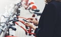 Young businesswomen in black suit and umbrella using smartphone, biking and going to work by city bicycle on urban street, hipste Royalty Free Stock Photo