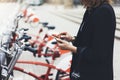 Young businesswomen in black suit and umbrella using smartphone, biking and going to work by city bicycle on urban street, hipster Royalty Free Stock Photo