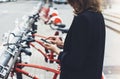 Young businesswomen in black  suit and umbrella using smartphone, biking and going to work by city bicycle on urban street Royalty Free Stock Photo
