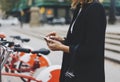 Young businesswomen in black suit and umbrella using smartphone, biking and going to work by city bicycle on urban street Royalty Free Stock Photo