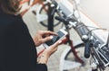 Young businesswomen in black  suit and umbrella using smartphone, biking and going to work by city bicycle on urban street Royalty Free Stock Photo