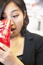 Young businesswomen looking into traditional red envelopment, Chinese New Year