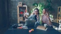 Young businesswomen are making selfie together in modern office while sitting at desk. They are posing with funny faces Royalty Free Stock Photo