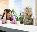 Young businesswomen smiling at cafeteria table Royalty Free Stock Photo