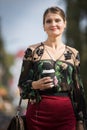 Young businnes lady walking on street with coffee