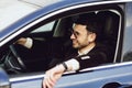 Young bussinesman in suit and black glasses driving his car. Bussines look. Test drive of the new car Royalty Free Stock Photo