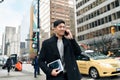 Young busy happy Asian business man walking on city street making phone call. Royalty Free Stock Photo