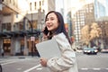 Young busy happy Asian business woman walking on city street making phone call. Royalty Free Stock Photo