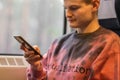 Young busy man using smartphone when he traveling by train. Man sits at the train window and chatting in social media. Royalty Free Stock Photo