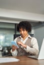 Young busy African American business woman using mobile phone in office. Royalty Free Stock Photo