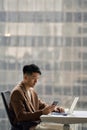 Young busy Asian Japanese business man using phone in office, vertical. Royalty Free Stock Photo